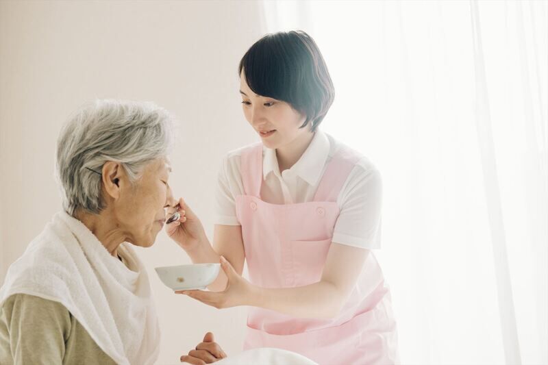食事の介助をする女性ヘルパー